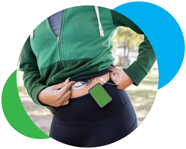 A woman standing outside with diabetic medical equipment placed on her abdomen. 