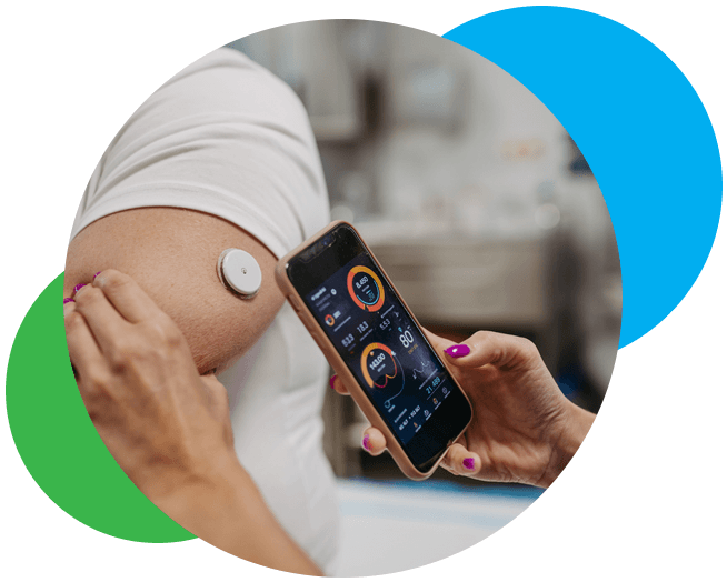A man sitting down and smiling as he checks his glucose levels. 